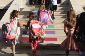 Μαθητές με τις τσάντες τους στην πλάτη ανεβαίνουν τα σκαλιά για να μπουν στο σχολείο τους