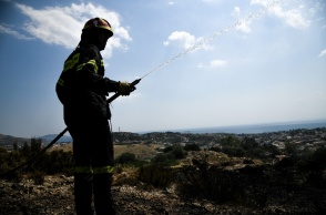 Πυροσβέστης με μάνικα ανά χείρας κατά τη διάρκεια κατάσβεσης