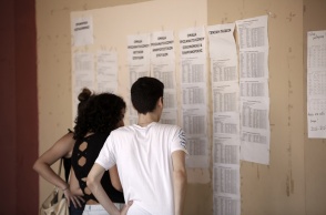 Υποψήφιοι έξω από σχολείο βρέπουν ανηρτημένα τα αποτελέσματα των Πανελληνίων μετά την ανακοίνωση των βάσεων