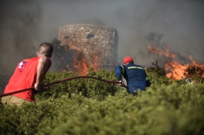 Πυροσβέστης και εθελοντής κατά τη διάρκεια κατάσβεσης πυρκαγιάς