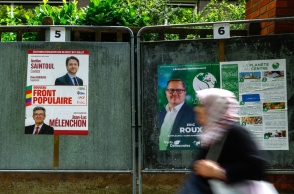Πολίτες μπροστά από αφίσες εκλογών στη Γαλλία