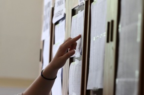 Χέρι που αναζητά τα αποτελέσματα των Πανελληνίων 2024