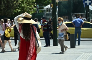 Πολίτες περπατούν στο κέντρο της Αθήνας ενόψει καύσωνα