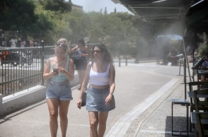 Γυναίκες στο κέντρο της Αθήνας παιρνούν από spot δροσιάς καταστήματος εστίασης