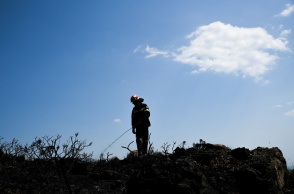 Η σιλουέτα πυροσβέστη διακρίνεται στην κορυφή υψώματος