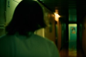 Γυναίκα σε σκοτεινό διάδρομο - Εικόνα που παραπέμπει σε κακοποίηση και ενδοοικογενειακή βία