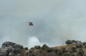 Καπνοί και πυροσβεστικό ελικόπτερο που επιχειρεί στη φωτιά στο Ρέθυμνο