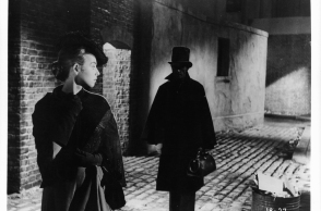 Άγνωστη ηθοποιός κοιτάζει πίσω σε έναν άνδρα που την ακολουθεί σε μια σκηνή από την ταινία «Jack The Ripper», 1959