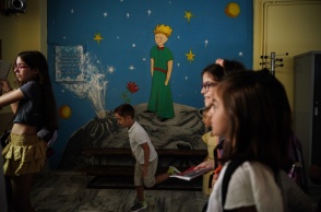 Μαθητές σε σχολείο μπροστά από τοιχογραφία με τον Μικρό Πρίγκιπα