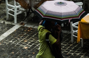 Πολίτες με ομπρέλες προστατεύονται από τη βροχή
