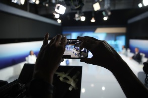 Χέρι τραβά φωτογραφία από κινητό κατά τη διάρκεια του debate μεταξύ των έξι υποψηφίων του ΠΑΣΟΚ