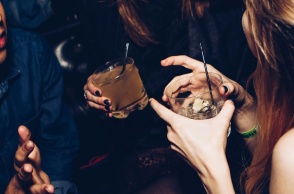 Άτομα σε κλαμπ κρατούν τα ποτήρια με το ποτό τους