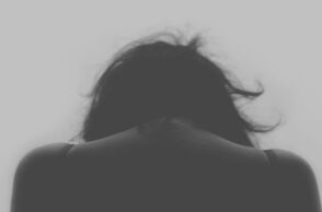 Γυναίκα με σκυμμένο κεφάλι υποδηλώνοντας πως έχει δεχτεί επίθεση