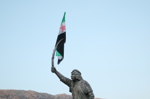 Η σημαία της συριακής αντιπολίτευσης κρέμεται από το ξίφος του αγάλματος του Δρούζου Σουλτάνου Αλ-Ατράς Πασάατ 