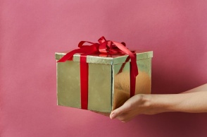 Χέρι με δώρο τυλιγμένο με κορδέλα