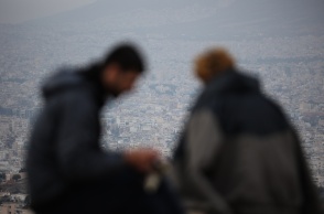 Δύο άτομο με φόντο τη συννεφιασμένη Αθήνα