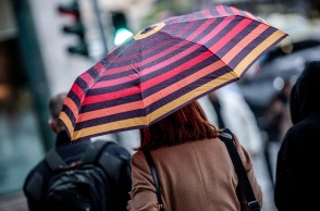 Γυναίκα με ομπρέλα προστατεύεται από τη βροχή