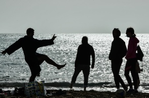 Σκιές ατόμων που βρίσκονται στην ακρογυαλιά