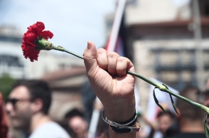 Χέρι κρατά κόκκινο γαρύφαλλο