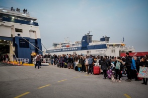 Επιβάτες σχηματίζουν ουρά έξω από πλοίο στο λιμάνι του Πειραιά