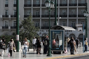 Πολίτες περιμένουν σε στάση λεωφορείου