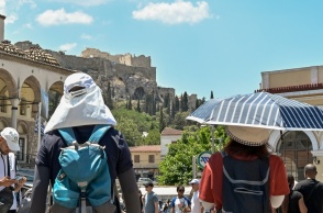Πολίτες με καπέλα εν μέσω καύσωνα στο κέντρο της Αθήνας