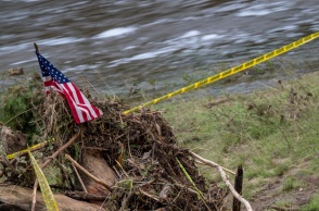 Φερτά υλικά κάνουν βουναλάκι δίπλα από πλημμυρισμένο χώρο στο Τέξας - Πάνω τους μία σημαία των ΗΠΑ