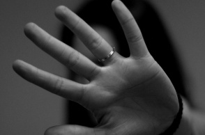 Γυναίκα που προτάσσει το χέρι της για να κρύψει το πρόσωπό της