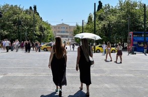 Γυναίκες με ομπρέλες προστατεύονται από τον ήλιο εν μέσω καύσωνα