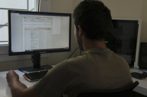 Άτομο διαβάζει τις βάσεις Πανελληνίων στον υπολογιστή της