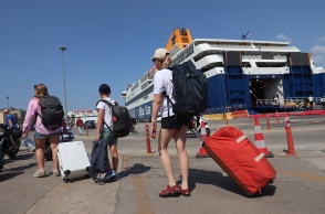Ταξιδιώτες με τις βαλίτσες στο χέρι στο λιμάνι του Πειραιά