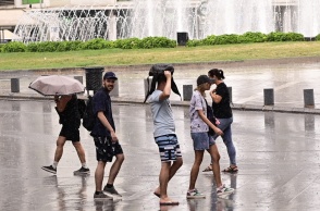Πολίτες περπατούν εν μέσω βροχής