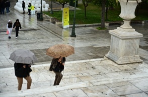 Πολίτες με ομπρέλες στο κέντρο της Αθήνας