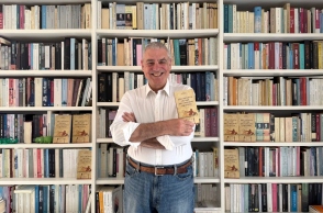 Ο Ξενοφών Μπρουτζάκης μπορστά από τη βιβλιοθήκη του