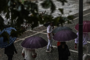 Πολίτες με ομπρέλες εν μέσω βροχής
