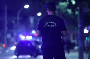 Αστυνομικός μπροστά από περιπολικό