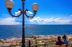 Άτομα σε παγκάκι που κοιτούν τη θάλασσα