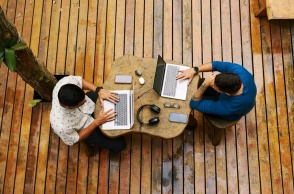 Δύο άνδρες που εργάζονται στα λάπτοπ τους