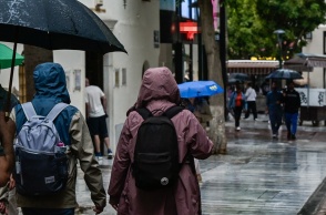 Πολίτες με ομπρέλες προστατεύονται από τη βροχή