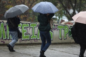 Άτομα με ομπρέλες εν μέσω βροχής
