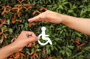 Ένα χέρι κρατάει το σήμα των ΑμεΑ και ένα άλλο το προστατεύει