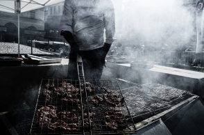 Άτομο ψήνει σε σκάρα και κάρβουνα  κρέας