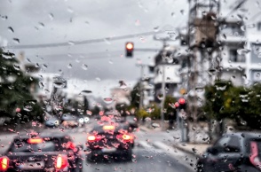 Σταγόνες βροχής στο παρμπρίζ αυτοκίνητου ενώ μέσω καταιγίδας