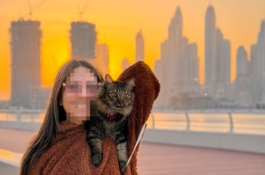 Γυναίκα με γατούλα στον ώμο με φόντο το Ντουμπάι