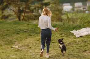 Γυναίκα βγάζει βόλτα τον σκύλο στην εξοχή