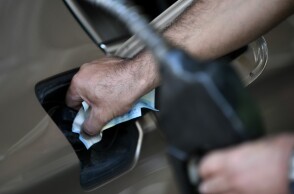 Υπάλληλος σε πρατήριο υγρών καυσίμων βάζει βενζίνη σε αυτοκίνητο