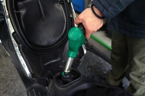 Υπάλληλος σε πρατήριο υγρών καυσίμων βάζει βενζίνη στη μηχανή