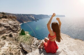 Γυναίκα με κόκκινο φόρεμα με φόντο παραλία το καλοκαίρι