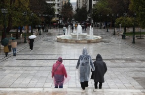 Πολίτες με αδιάβροχα στην πλατεία Συντάγματος