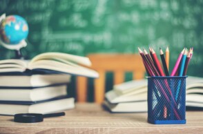 Βιβλία, μολυβοθήκη και υδρόγειος πάνω σε γραφείο στη σχολική αίθουσα